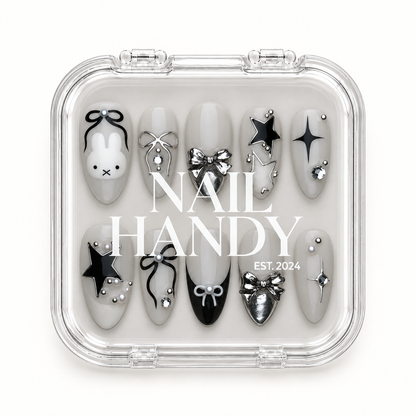 Clear Nail Handy case displaying ten greige bunny, bow, and star nails against a light background.