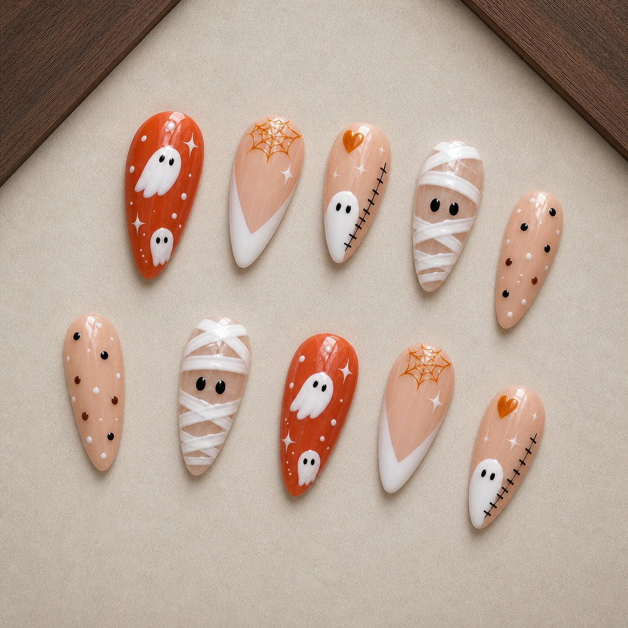 Creamsicle Spirits Halloween press-on nail set displayed in a walnut tray — almond shape