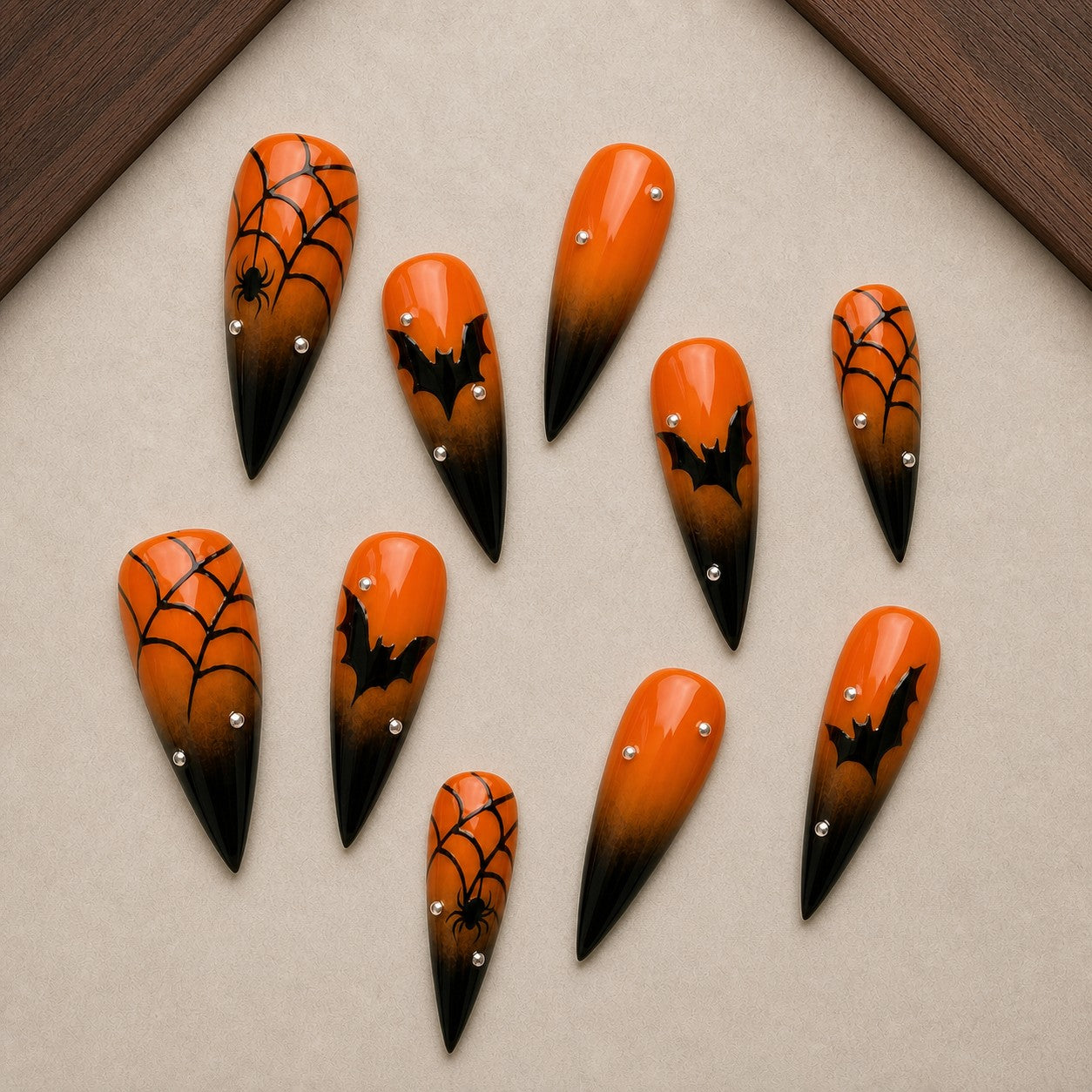 Ember Web Halloween press-on nail set displayed in a walnut tray — stiletto shape