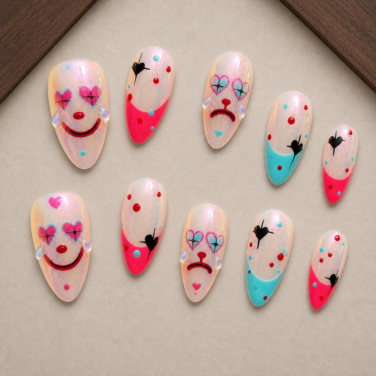 Harlequin Heart Halloween press-on nail set displayed in a walnut tray — almond shape