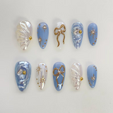 Blue Pearl Bow press-on nails with 3D gold bow charm on almond