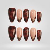 Tortoise Chic almond press-on nails with gold charm