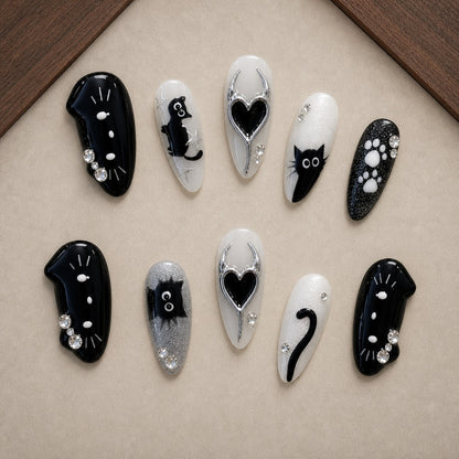 Moonlit Whiskers Halloween press-on nail set displayed in a walnut tray — almond shape