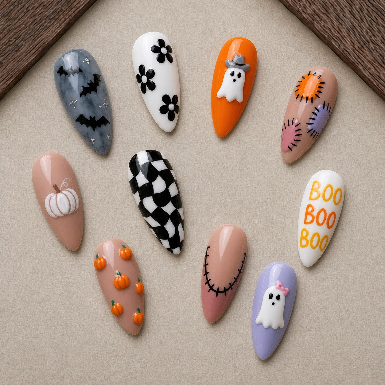 Patchwork Boo Halloween press-on nail set displayed in a walnut tray — almond shape