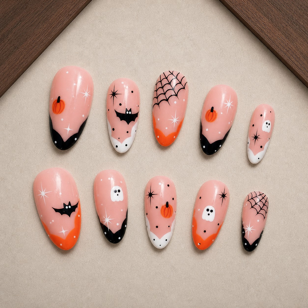 Peachy Phantom Halloween press-on nail set displayed in a walnut tray — almond shape