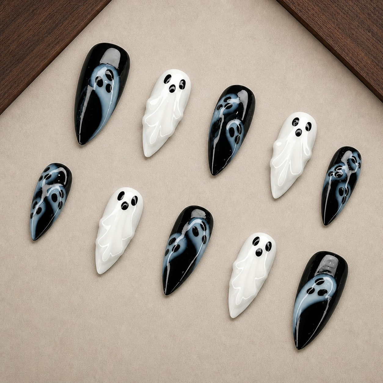 Phantom Noir Halloween press-on nail set displayed in a walnut tray — almond shape