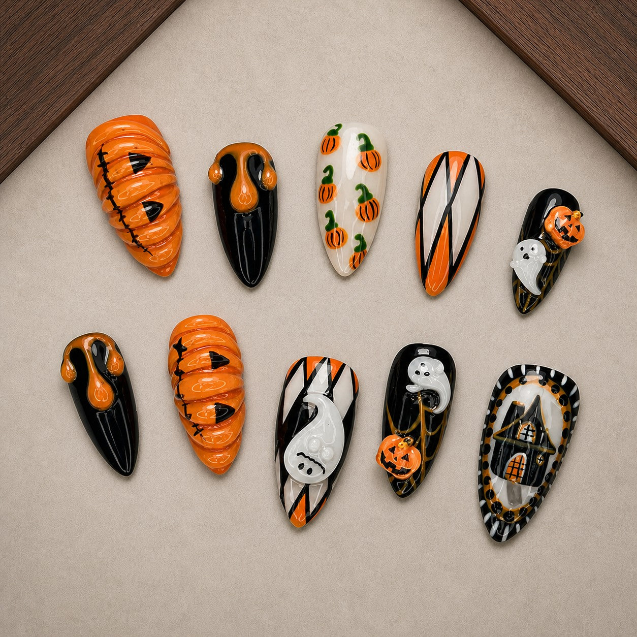Pumpkin Parlor Halloween press-on nail set displayed in a walnut tray — almond shape
