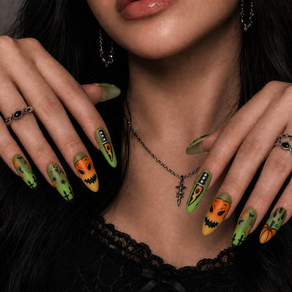 Wicked Patch Halloween press-on nails in almond shape worn on model hand — pumpkin, horror, graveyard nail art