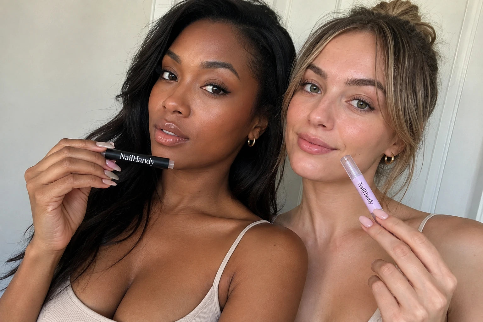 Two models showing their manicures and holding NailHandy products